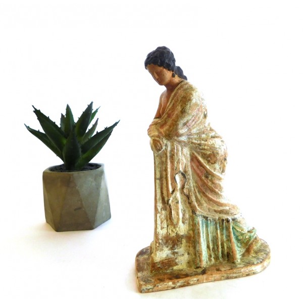 Terracotta figurine standing by a column